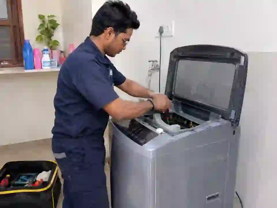Technician repairing a top load washing machine in Delhi